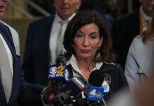 Woman speaking to reporters at a press scrum