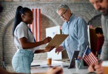 Voter signs a form at a polling station desk