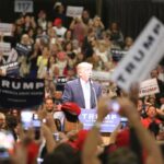 Donald Trump speaks at a rally podium as a large crowd cheers; Orel Hershiser, Ion Marin, and Billy Joe DuPree present