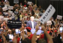 Donald Trump speaks at a rally podium as a large crowd cheers; Orel Hershiser, Ion Marin, and Billy Joe DuPree present