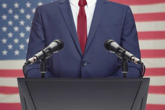 Speaker in suit at podium with microphones