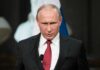 Vladimir Putin speaking at a podium with a microphone