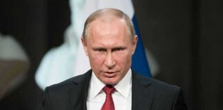 Vladimir Putin speaking at a podium with a microphone